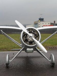 Front view of silver colored model aircraft in the runway