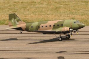 Camouflage colored model aircraft in action at an event