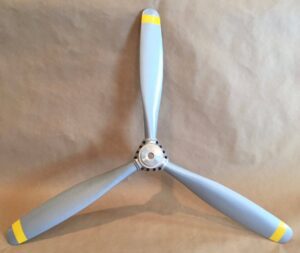 Light colored propellor resting in front of a wall